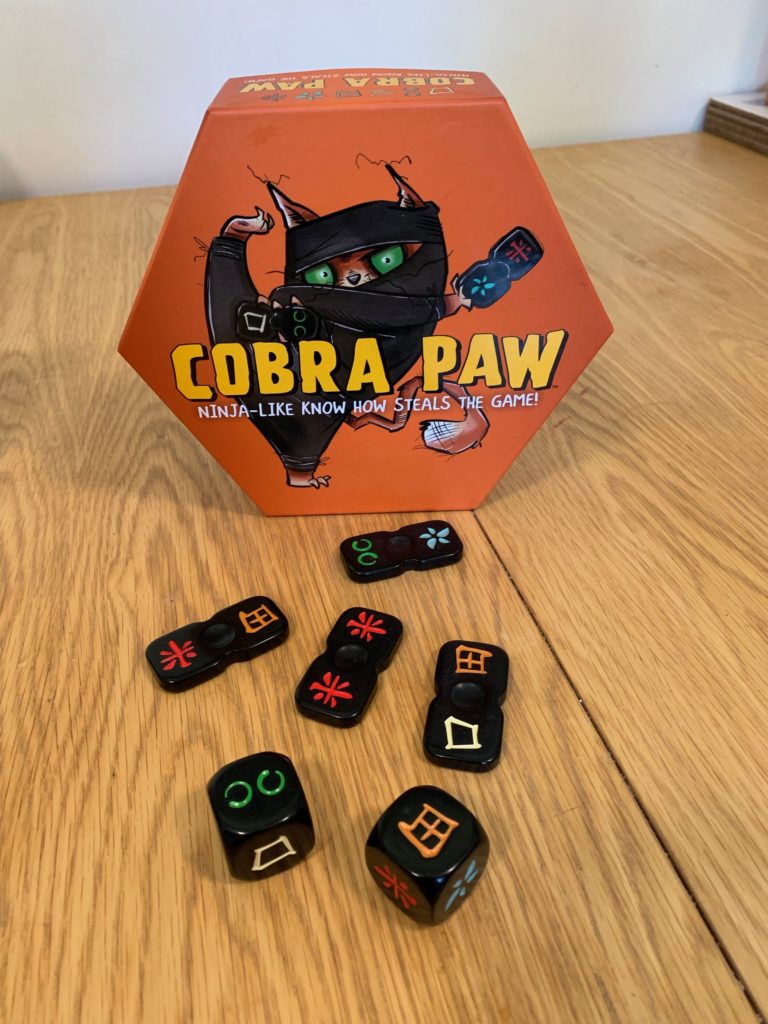 Cobra paw the game with tiles in front of the box